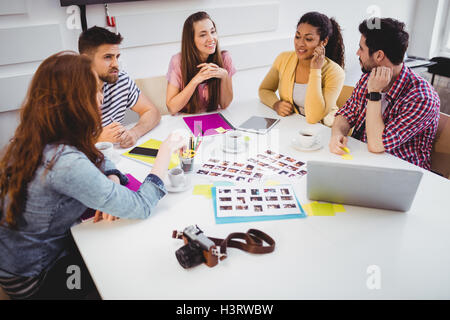 Editoren diskutieren Fotografien in Besprechung Kreativbüro Stockfoto