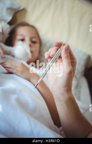 Mutter, Töchter Temperatur am Thermometer überprüfen Stockfoto