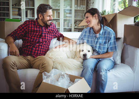 Paar auf Sofa mit ihrem Haustier Hund Stockfoto
