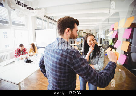 Geschäftsfrau sucht Mitarbeiter auf Notizzettel schreiben Stockfoto