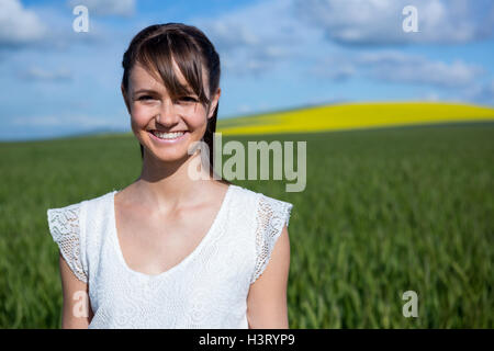 Glückliche junge Frau im Feld stehen Stockfoto