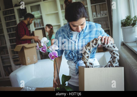 Frau Auspacken der Kartons im Familie stehen im Hintergrund Stockfoto