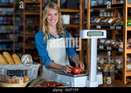 Weibliche Personal Gewichtung Gemüse auf Skala im Supermarkt Stockfoto