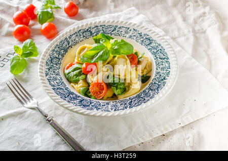 Tortellini gefüllt mit Fleisch mit gerösteten Tomaten und Basilikum, Olivenöl Stockfoto