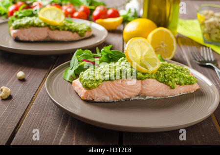 Gebackener Lachs gedünstet mit Pesto und frischem Salat Stockfoto
