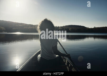 Junge Frau Kanufahren auf einem See im Herbst. Muskoka, Ontario, Kanada. Stockfoto