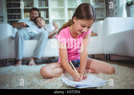 Mädchen auf dem Boden sitzen und zeichnen Stockfoto