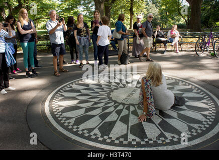 Touristen auf dem Vorstellen, Mosaik Denkmal für John Lennon in Strawberry Fields posieren. Central Park, Manhattan, New York. Stockfoto