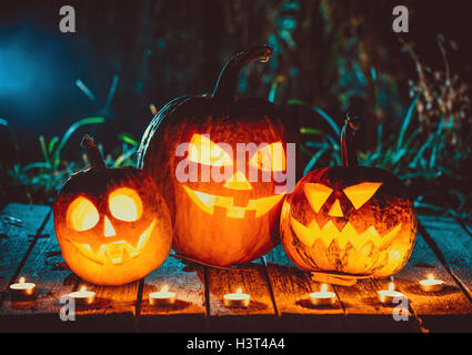 Halloween Kürbisse Kopf jack Laterne mit Kerzen um auf den alten Platten in einer gespenstischen Nacht Landschaft. Soft Focus. seichte dof Stockfoto