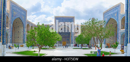 Der Innenhof des Ulugh Beg Madrasah mit kleinem Garten und traditionellen islamischen Mosaiken an den Wänden in Samarkand. Stockfoto