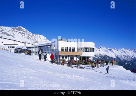 Österreich, Tirol, St. Anton Berg Arl, Arlberggebiet, Bergrestaurant, Sonnenterrasse, Galzig, Skifahren in den Bergen Arl, Skigebiet, Galzig, Bergstation, Skifahrer, Winter Winterlandschaft, Bergregion, Berglandschaft, Berge, Skiregion, sind Stockfoto