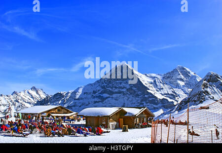 Nach dem Skifahren auf dem Gipfel des Mannlichen, Grindelwald, Schweiz, entspannen sich die Touristen auf den Liegen Stockfoto