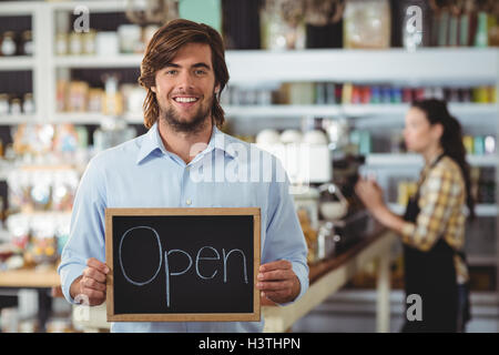 Porträt der Kellner zeigt Tafel mit Schild "geöffnet" Stockfoto