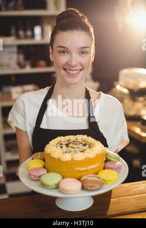 Porträt der Kellnerin Kuchenplatte Dessert festhalten Stockfoto