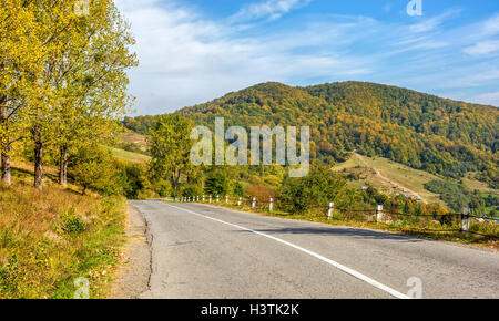 Straße durch die Hügel in der Nähe von herbstlichen Wald Stockfoto