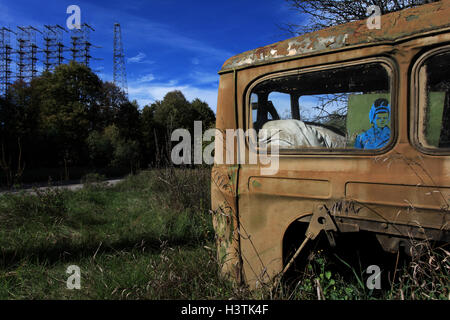 Verlassenes Auto in der ehemaligen militärischen Basis Chernobyl-2 um das sowjetische Radarsystem Duga-3. Sperrzone von Tschernobyl, Ukraine. Stockfoto