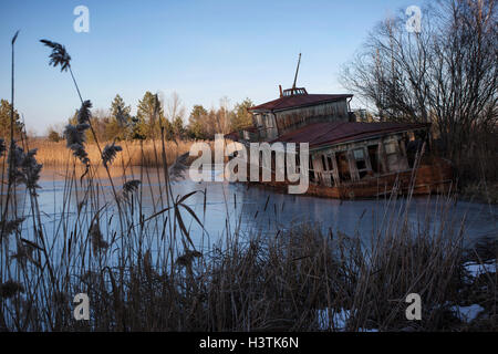 Verlassene Schiffswrack am Ufer des Flusses Pripjat nach der Tschernobyl-Katastrophe. Pripyat, Sperrzone von Tschernobyl, Ukraine. Stockfoto