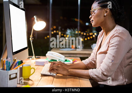 Geschäftsfrau, die auf Computer an ihrem Schreibtisch arbeiten Stockfoto