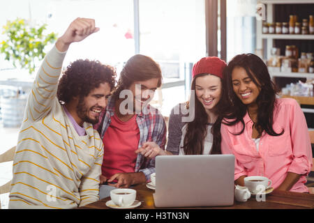 Gruppe von Freunden mit Laptop bei Tasse Kaffee Stockfoto