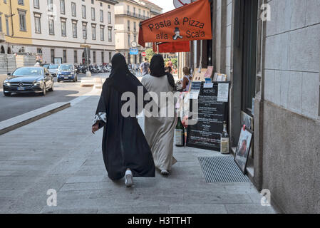 Zwei junge Frauen in muslimischen traditionelle Kleidung sind Fuß entlang der Straße von Mailand, Italien, Europa Stockfoto