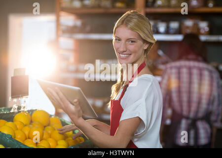 Freundliches Personal mit digital-Tablette während der Überprüfung Früchte im organischen Bereich Stockfoto