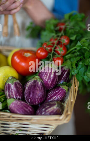 Nahaufnahme des weiblichen Personals hält Korb mit Gemüse im organischen Bereich Stockfoto