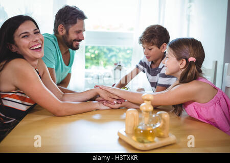 Eltern und Kinder setzen ihre Hände zusammen am Tisch Stockfoto
