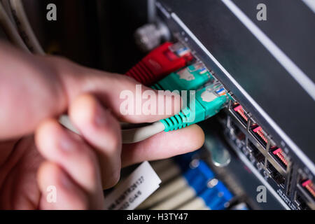 Techniker einstecken Ethernet in einem Rack montiert server Stockfoto