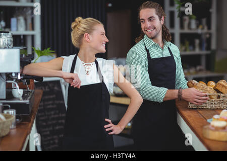 Kellner und Kellnerin Lächeln einander an Stockfoto