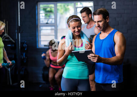 Mann und Frau auf der Suche auf Tablettcomputer im Fitness-Studio Stockfoto