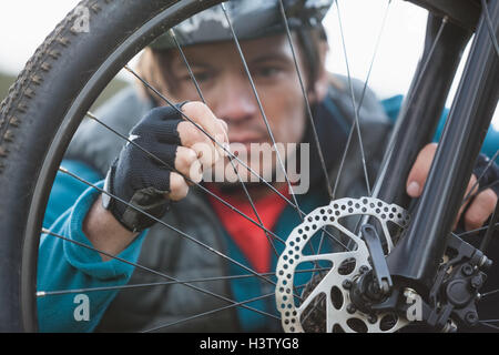 Männliche Mountainbiker Vorderrad seines Fahrrades prüfen Stockfoto