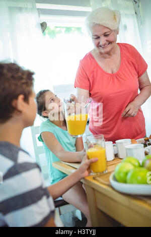 Großmutter Glas Orangensaft herein Stockfoto