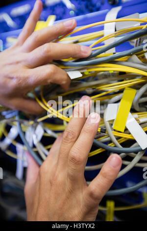 Techniker überprüfen Kabel in einem Rack montiert server Stockfoto