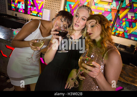 Drei Freundinnen, die mit Glas Champagner und Wein Stockfoto