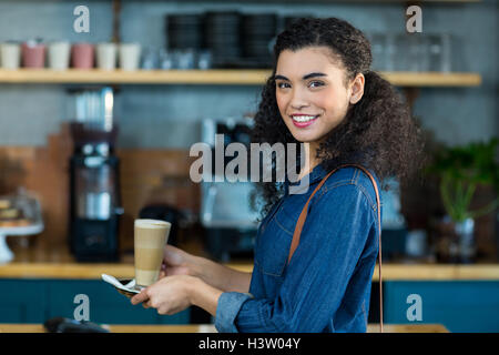 Lächelnde Frau hält eine Tasse Kaffee im caf├⌐ Stockfoto