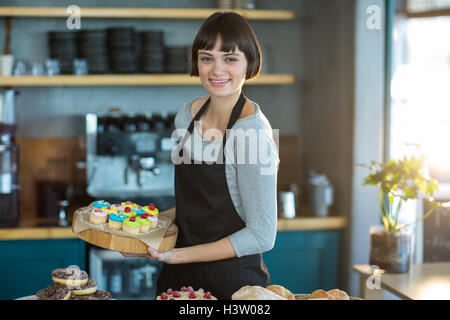 Porträt der Kellnerin Tablett in Caf├⌐ Tasse Kuchen festhalten Stockfoto