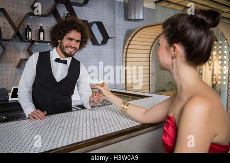 Kellner mit einem Cocktail Frau am Tresen Stockfoto