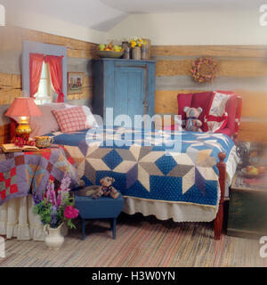 1990ER JAHRE BETT MIT DECKE UND KISSEN DRAUF UND VASE MIT BLUMEN ON STOCK IM BLOCKHAUS-SCHLAFZIMMER Stockfoto