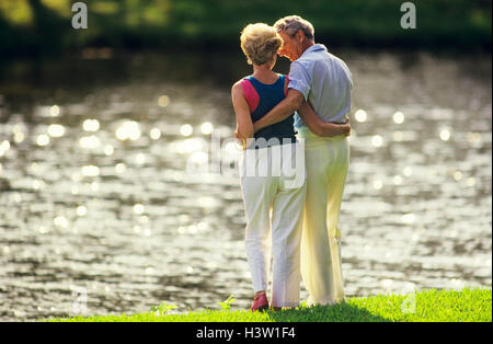 RÜCKANSICHT DES ROMANTISCHEN ÄLTERES PAAR AM SEE 'S EDGE Stockfoto