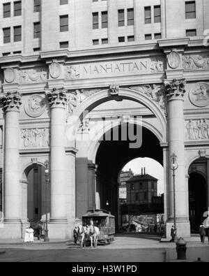 1900S 1916, DIE EINES DER LETZTEN PFERD GEZEICHNETEN WAGEN KOMMEN DURCH ARCH OF THE MUNICIPAL BUILDING LOWER MANHATTAN NEW YORK CITY USA Stockfoto