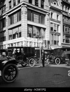 1910ER JAHRE EIN POLIZIST STEUERT DEN DATENVERKEHR AUF FIFTH AVENUE VOR DEM ERSTEN WELTKRIEG MIT EINEM HAND-SEMAPHORE SIGNAL NEW YORK CITY USA BETRIEBEN Stockfoto