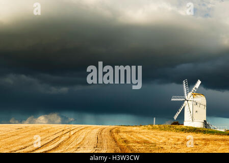 Ashcombe Windmühle als Gewitterwolken Ansatz aus North, East Sussex, Großbritannien durch niedrige Nachmittagssonne beleuchtet Stockfoto