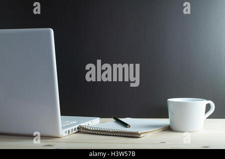 Arbeitsplatz mit Laptop und Kaffee am Schreibtisch aus Holz. Stockfoto