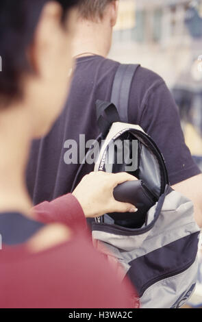 Mann, jung, zurück Blick, Taschendieb, Hand, Rucksack, Geldbörse, stehlen, Detail, Kriminalität, Raub, stehlen, stehlen, Geldbörse, Verbrecher, begehen eines Verbrechens, kriminell, Taschendiebstahl, Diebstahl, Dieb, leichtfertig, Unachtsamkeit, achtlos, Licht, Wärme Stockfoto