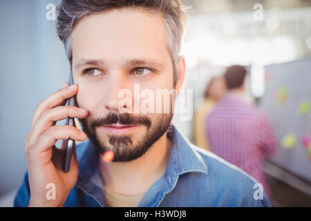 Nahaufnahme der Geschäftsmann Handy bei Kreativbüro anhören Stockfoto