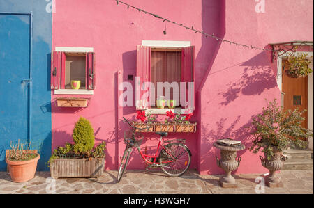 altes violettes Fahrrad geparkt lange eine Außenwand in Insel Burano, Venedig Stockfoto