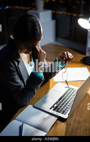 Betonte Geschäftsfrau sitzt an ihrem Schreibtisch Stockfoto