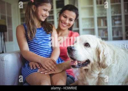 Mutter und Tochter sitzen mit Hund im Wohnzimmer Stockfoto