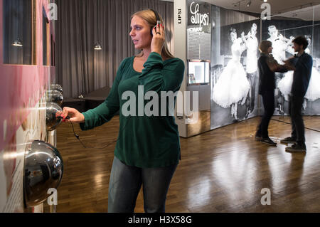 Bremen, Deutschland. 7. Oktober 2016. Ein Besucher der Focke-Museum-Plays ins Deutsche hit Musik aus den 1960er Jahren in der Sonderausstellung "Oh ja!" in Bremen, Deutschland, 7. Oktober 2016. Unterdessen tanzen zwei Besucher im Hintergrund zu Musik aus den 1950er Jahren. Die multimediale Ausstellung widmet sich der Geschichte der Popmusik. Foto: INGO WAGNER/Dpa/Alamy Live News Stockfoto