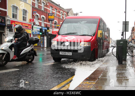 London, UK. 13. Oktober 2016. Ein Bus fährt durch eine Wasserpfütze Credit: Dinendra Haria/Alamy Live News Stockfoto